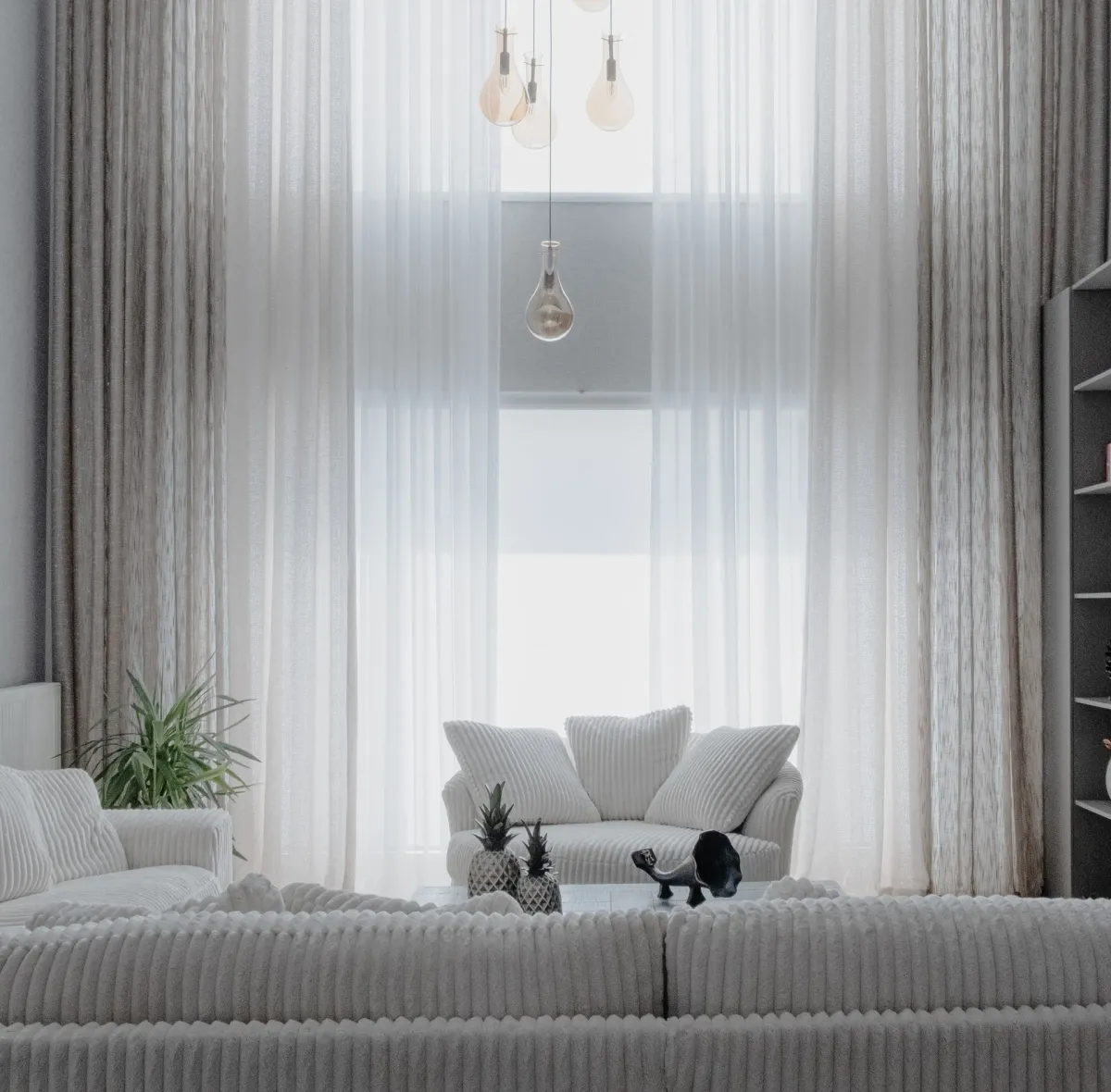 Sala clara com sofás brancos e cortinas leves